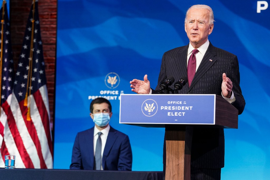 Former South Bend, Ind., Mayor Pete Buttigieg listens as President-elect Joe Biden announces Buttigieg as his nominee for transportation secretary during a news conference.