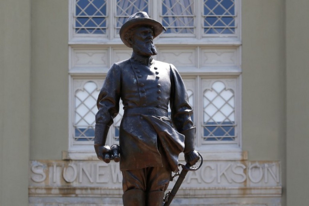 A statue of Confederate General Stonewall Jackson stands behind canons at the entrance to the barracks at Virginia Military Institute Wednesday July 15, 2020, in Lexington, Va.