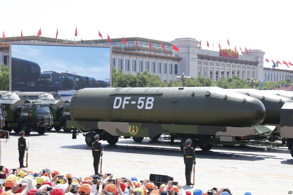 Military vehicles carry DF-5B intercontinental ballistic missiles during a parade.