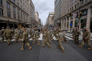 National Guardsmen walk across deserted 14th Street as roads are blocked and security heightened ahead of President-elect Joe Biden's inauguration ceremony, Monday, Jan. 18, 2021, in Washington.