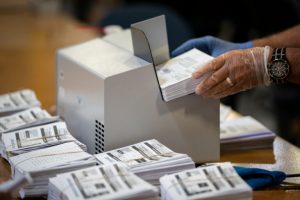 GLEN BURNIE, MD – OCTOBER 07: A canvasser wore gloves while processing mail-in ballots in a warehouse at the Anne Arundel County Board of Elections headquarters on October 7, 2020 in Glen Burnie, Maryland.