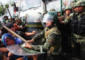 Chinese policemen push Uighur women protesting in Urumqi, capital of Xinjiang region in China.