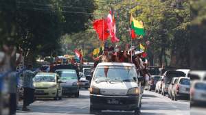 Buddhist religious and military flags are waved by supporters including Buddhist monks onboard a vehicle Monday, Feb. 1, 2021, in Yangon, Burma.