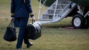 FILE - A military aide carries the alleged 'football,' a case with the launch codes for nuclear weapons, toward Marine One as former President Donald Trump prepares to take off.