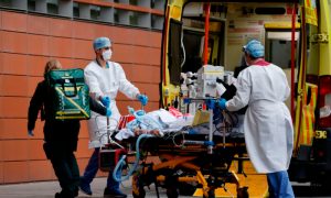 Medics take a patient from an ambulance into the Royal London hospital in London on Jan. 19, 2021.