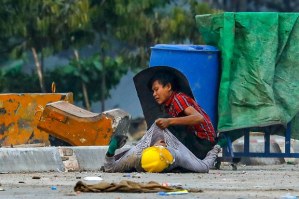 A protester holds onto the shirt of a fallen comrade, during a crackdown by security forces on demonstrations against the military coup, in Hlaingthayar township in Yangon, March 14, 2021.