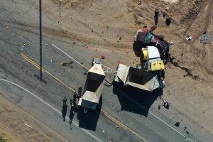 California Highway Patrol officers investigate a crash site after a collision between a Ford Expedition sport utility vehicle and a tractor-trailer truck in Holtville, Calif.