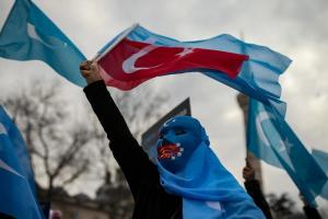 A protester from the Uyghur community living in Turkey waves a Turkish flag during a protest against the visit of China's Foreign Minister Wang Yi to Turkey, in Istanbul, Thursday, March 25, 2021.
