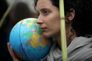 FILE- In this Nov. 29, 2019, file photo, a demonstrator holds a terrestrial globe in Lisbon during a worldwide protest demanding action on climate change.