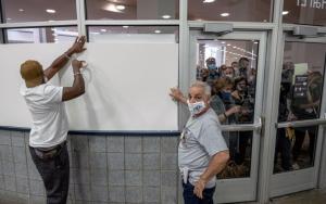Poll workers board up windows at Detroit's TCF Center so observers can't see ballots being counted, Nov. 4,2020.