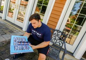 In this June 9, 2017, file photo, Grant Berardo, a student at Wall High School, flips through his 2017 school yearbook in Wall, N.J. The yearbook includes a photo of him wearing a digitally altered T-shirt that originally included the words "Trump Make America Great Again."