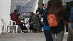 A member of the International Organization for Migration takes a child's temperature before crossing the border into El Paso, Texas at the Leona Vicario shelter in Ciudad Juarez, Mexico, Friday, Feb. 26, 2021.
