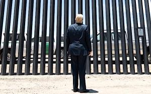 President Donald J. Trump stands before a plaque Tuesday, June 23, 2020, commemorating the 200th mile of new border wall along the U.S.-Mexico border near Yuma, Arizona.