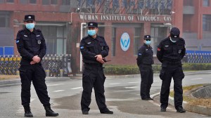 Security personnel gather near the entrance of the Wuhan Institute of Virology during a visit by the World Health Organization team,