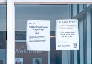 A Rite Aid store in Coloma, Mich., posts a sign of COVID-19 capacity restrictions on April 23, 2020. 