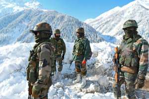 Indian army soldiers stand on a snow-covered road near Zojila mountain pass, bordering China. (TAUSEEF MUSTAFA/AFP via Getty Images/TNS)