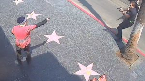 A suspect is seen pointing an object toward a police officer along the Hollywood Walk of Fame, July 15, 2021. (Los Angeles Police Department)