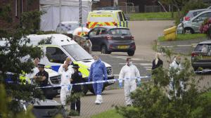 Forensic officers walk in Biddick Drive in the Keyham area of Plymouth, England on Friday, where six people were killed in a shooting incident. (Ben Birchall/PA via AP)