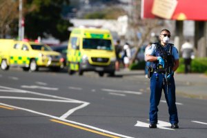 A police officer stands outside an Auckland supermarket, Friday, Sept. 3, 2021. New Zealand authorities said Friday they shot and killed a violent extremist after he entered a supermarket and stabbed and injured several shoppers. Prime Minister Jacinda Ardern described the incident as a terror attack. (Alex Burton/New Zealand Herald via AP)