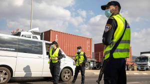 Israeli police check cars with Palestinian laborers as they search for two Palestinians who broke out of a maximum-security prison last week, on a road leading to the West Bank town of Jenin, near Gan Ner Israel, Sunday, Sept. 12, 2021. (AP Photo/Ariel Schalit)