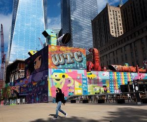 A woman walks by the colorful murals that surround the foundation for 2 World Trade Center, Wednesday, Sept. 8, 2021 in New York. (Mark Lennihan/AP)
