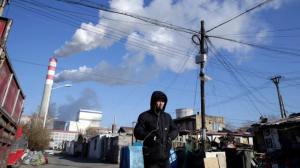 A man walks near a coal-fired power plant in Harbin, Heilongjiang province. Surging coal prices, as well as Beijing's efforts to curb emissions, have caused a power crunch.    © Reuters