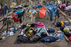 Haitian immigrants lie in their makeshift dwelling constructed of tree branches and carrizo cane.
John Moore/Getty Images