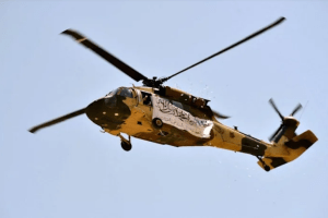 A helicopter displaying a Taliban flag fly above of supporters gathered to celebrate the US withdrawal of all its troops out of Afghanistan, in Kandahar on September 1, 2021. JAVED TANVEER/AFP via Getty Images