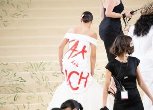 Rep. Alexandria Ocasio-Cortez (D-NY), appears at the 2021 Met Gala maskless in her highly fashionable and subversive gown, as masked workers and servants surround her, ensuring her safety and a smoothly running party, on September 13, 2021 in New York City. (Photo by Noam Galai/GC Images)