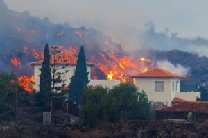 Lava flows behind a house following the eruption of a volcano in the Cumbre Vieja national park at Los Llanos de Aridane, on the Canary Island of La Palma, September 20, 2021. REUTERS/Borja Suarez