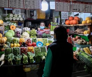 A woman browses through vegetables at a neighbourhood market in Beijing on Nov. 2, 2021. (JADE GAO/AFP via Getty Images)