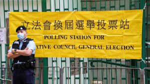 A police officer stands guard outside a polling station in Hong Kong on Dec. 19, 2021. (Vincent Yu/AP Photo)