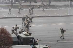 (4/16)
Unidentified military personnel fire their weapons in the center of Almaty on January 6. In video of this scene, the man at right appears to be signaling to stop shooting after a sustained burst of gunfire from the formation.