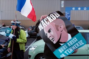 A man holds a banner reading "Macron, piss off too !" as he attends the "Convoi de la Liberté" in Nice, southeastern France, on february 9, 2022. -    (Photo by VALERY HACHE/AFP via Getty Images)