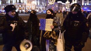 Police officers detain a demonstrator with a poster that reads: "I'm against the war", in Moscow, Russia, (AP Photo/Denis Kaminev)