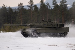 A Spanish Leopard tank drives through an open field near Rena, Norway during Exercise Brilliant Jump 2022.