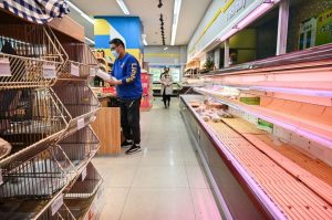 Shoppers rummage through empty shelves in a supermarket before a lockdown as a measure against the Covid-19 coronavirus in Shanghai on March 29, 2022. (HECTOR RETAMAL/AFP via Getty Images)