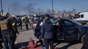 A woman waits on a stretcher to be carried across a destroyed bridge during an evacuation from Irpin, Ukraine on March 10, 2022. (Chris McGrath/Getty Images)