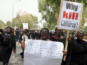 Thousands of women in black, one of them carrying a placard reading “Why Kill Children ?” as they march in protest at the slaughter of scores of mainly Christian villagers — many of them women and children. Wielding pictures of dead children and carrying Bibles in their hands, they hurled themselves onto a tarred road shouting “Enough is enough.” (PIUS UTOMI EKPEI/AFP via Getty)