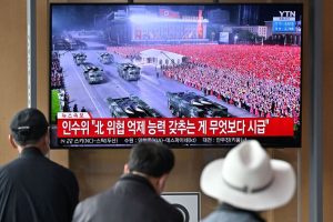 People watch a television screen showing a news broadcast of a military parade held in Pyongyang to commemorate the 90th founding anniversary of the Korean People’s Revolutionary Army, at a railway station in Seoul on April 26, 2022. (JUNG YEON-JE/AFP via Getty Images)