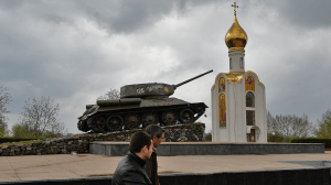 People pass next to a Soviet-era tank, now a monument celebrating the victory of the Red Army against fascist Germany, in Tiraspol, the main city of Trans-Dniester separatist region of Moldova, in April 2014.