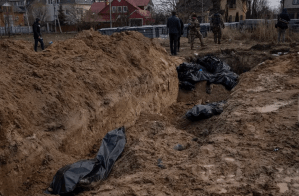 Image 5 of 8 WARNING: GRAPHIC IMAGE.
Journalists stand by a mass grave in Bucha, on the outskirts of Kyiv, Ukraine, Monday, April 4, 2022. Russia is facing a fresh wave of condemnation after evidence emerged of what appeared to be deliberate killings of civilians in Ukraine.  (AP Photo/Rodrigo Abd)