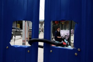 A man drives his bike inside a fenced residential area under a Covid-19 coronavirus lockdown in Beijing on May 11, 2022. Photo: Noel Celis/AFP