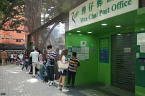 Individuals who got vaccinated outside Hong Kong may visit the 18 designated post offices in order to obtain a Provisional Vaccine Pass. Some started lining up at 5 a.m. as the post offices can only process 2,400 applications in one day. Photo: Lea Mok/HKFP.