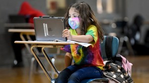Christina Pagan, 7, does her school work using an iPad and a pencil with a workbook.  (Ben Hasty/MediaNews Group/Reading Eagle via Getty Images)