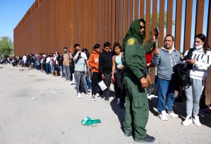 A United States Border Patrol agent checks for identification of immigrants as they wait in line to be processed after crossing from Mexico on May 21, 2022 in Yuma, Ariz.Mario Tama / Getty Images file