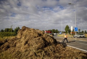 A man clears debris on a slip road of the A12 highway during a farmers’ demonstration against the government’s nitrogen policy, near Bunnik on July 27, 2022. – Netherlands OUT (Photo by Sem van der Wal / ANP / AFP) / Netherlands OUT (Photo by SEM VAN DER WAL/ANP/AFP via Getty Images)
