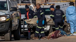 A body is removed from the scene of an overnight bar shooting in Soweto, South Africa, Sunday July 10, 2022. A mass shooting at a tavern in Johannesburg's Soweto township has killed 15 people. (AP)