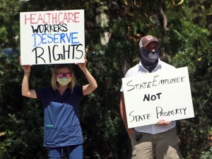 A nurse protests against COVID-19 vaccine and mask mandates near the state Capitol on Friday, Aug. 20, 2021, in Santa Fe, NM. (AP Photo/Cedar Attanasio)