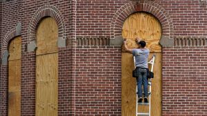 Workers board up the windows on the historical Henry B. Plant Hall on the campus of the University of Tampa ahead of Hurricane Ian, on Sept. 27, 2022, in Tampa, Fla.